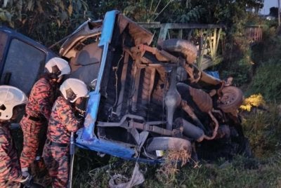 Anggota bomba cuba mengeluarkan mangsa yang tersepit dalam van kilang berkenaan. - foto BBP Bandar Baru Kulai