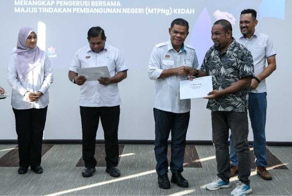 Saifuddin Nasution (tengah) menyampaikan dokumen kepada sebahagian kontraktor pada Majlis Penyerahan Inden Projek Mesra Rakyat hari ini. - Foto: Bernama