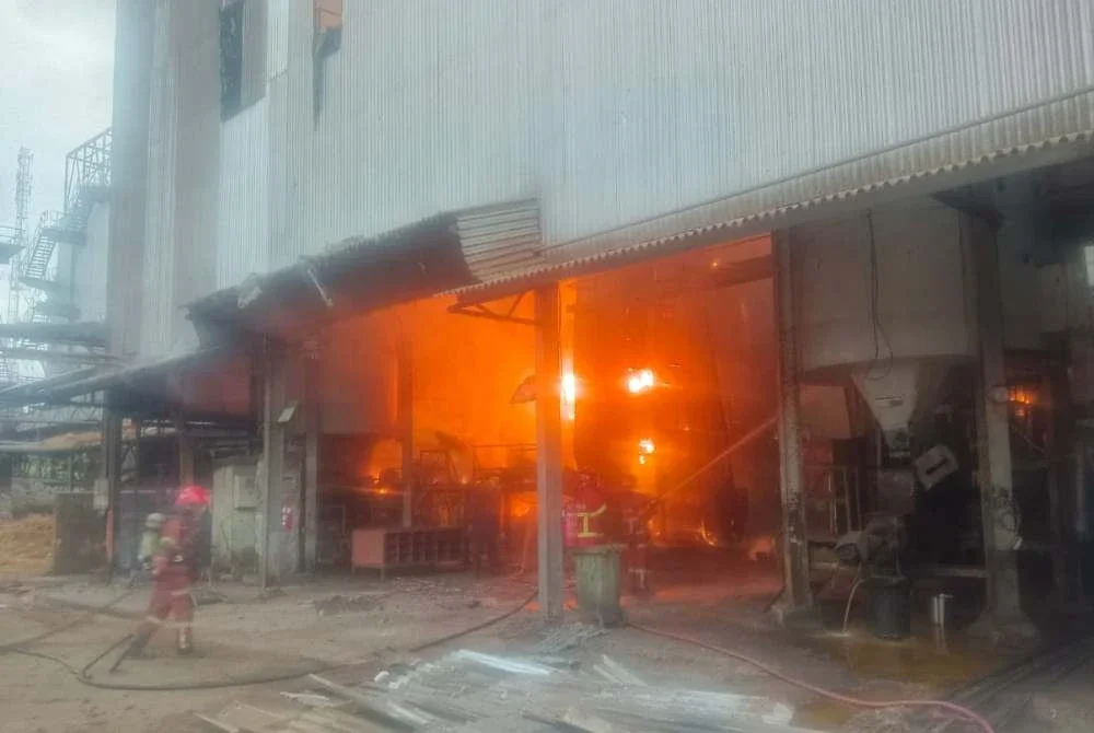 Anggota bomba bertungkus lumus mengawal kebakaran bagi mengelak api merebak dan memusnahkan kilang. Foto: JBPM Pahang