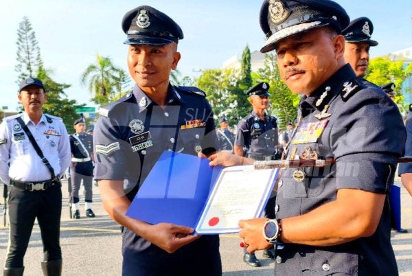 Mohd Yusoff (kanan) menyampaikan surat penghargaan
semasa Perhimpunan Bulanan Peringkat IPK Kelantan pada Ahad.