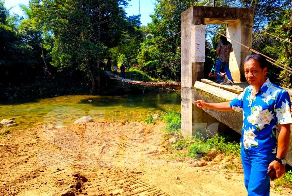 Mohd Zamri menunjukkan pembinaan jambatan baharu menggantikan titi gantung di Kampung Chatel Damai, Lata Rek, Kuala Krai sudah memasuki hari ketiga selepas ia runtuh pada 1 Januari lalu