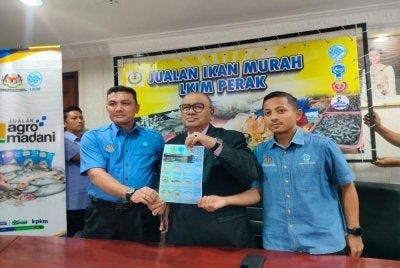 Mohd Zolkafly (tengah) menunjukkan poster Program Jualan Sejahtera Rakyat Ikan Murah dengan kerjasama LKIM Perak selepas sidang media di pejabatnya di sini pada Isnin.
