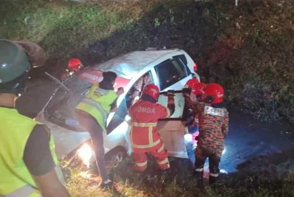 Anggota bomba sedang berusaha mengeluarkan mangsa yang tersepit di bahagian pemandu.