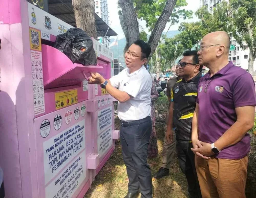 Joseph (kiri) menunjukkan cara meletakkan sisa tekstil untuk dikitar semula.