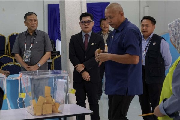 Ramlan (kiri) bersama Pegawai Pengurus PRK, Dr Eddy Syaizul Rizam Abdullah meninjau proses pengundian awal bagi PRK Parlimen Kinabatangan dan Dewan Undangan Negeri (DUN) Lamag di Teratak Ibu Pejabat Polis Daerah Kinabatangan pada Selasa. Foto Bernama