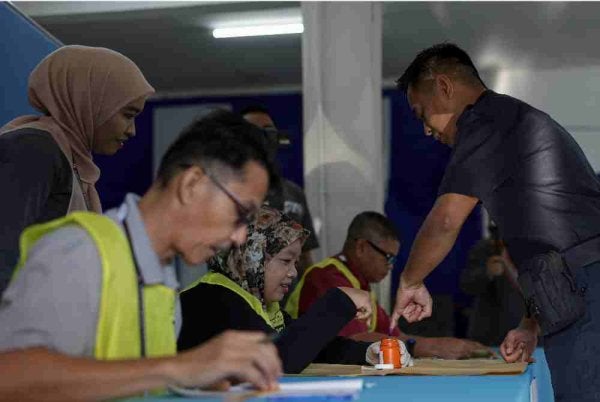 Anggota PDRM menunaikan tanggungjawab mengundi awal bagi PRK Parlimen Kinabatangan dan DUN Lamag di Teratak Ibu Pejabat Polis Daerah Kinabatangan, pada Selasa. Foto Bernama