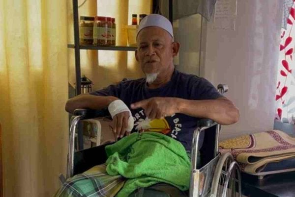 Abdul Rahman menunjukkan kecederaan pada tangannya dan luka pada kaki akibat diserang gajah di hadapan sekolah di Bandar Sri Perani, Kota Tinggi.