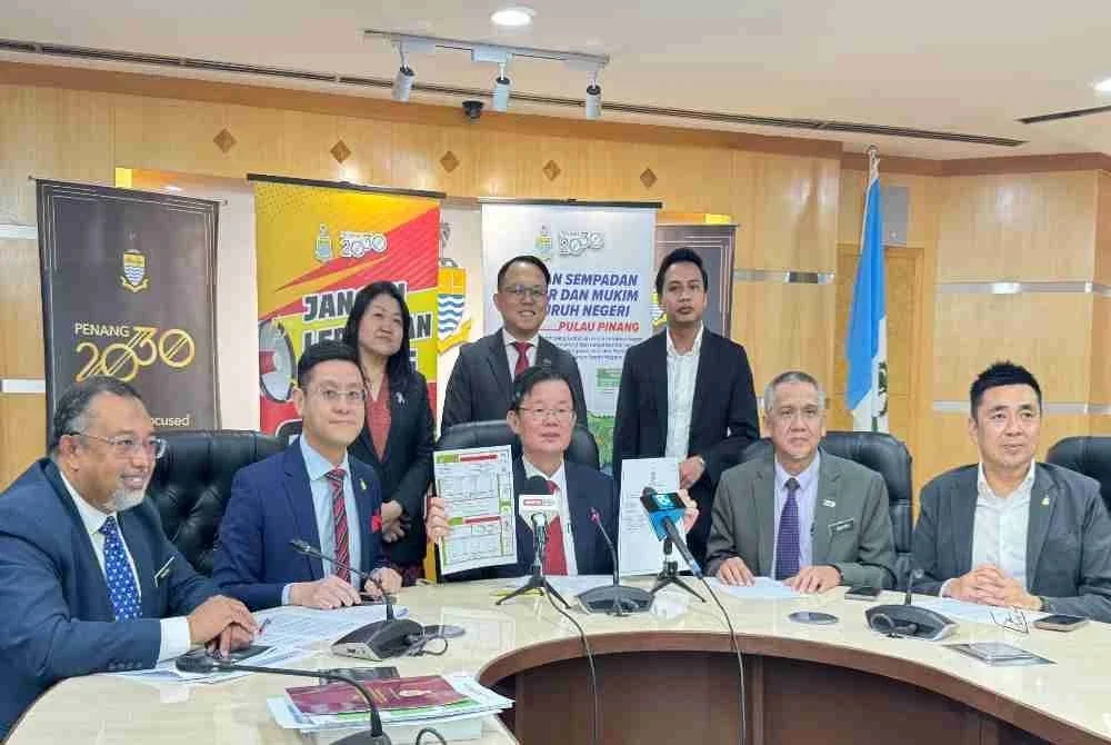 Kon Yeow (duduk, tengah) dan beberapa barisan Exco Kerajaan Negeri menunjukkan Warta Kerajaan Pulau Pinang dalam sidang akhbar di Komtar pada Rabu.