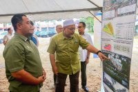 Wan Sukairi (kanan) menunjukkan RPMM yang akan dibina di Kampung Kubang Parit, Kuala Terengganu.