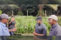 Ahmad Yunus (kiri) dan Ahmad Fadhli (dua dari kanan) meninjau keadaan perparitan yang dicemari air berwarna hitam dan berbau busuk di Kampung Tumbuk pada Rabu.