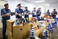 Rohaizad (dua dari kiri) bersama pegawainya menunjukkan rokok pelbagai jenama dan minuman keras yang dirampas pada sidang media di Kompleks Penguasaan JKDM Negeri, Butterworth hari ini. Foto Bernama
