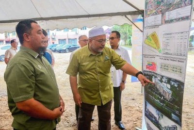 Wan Sukairi (kanan) menunjukkan RPMM yang akan dibina di Kampung Kubang Parit, Kuala Terengganu.