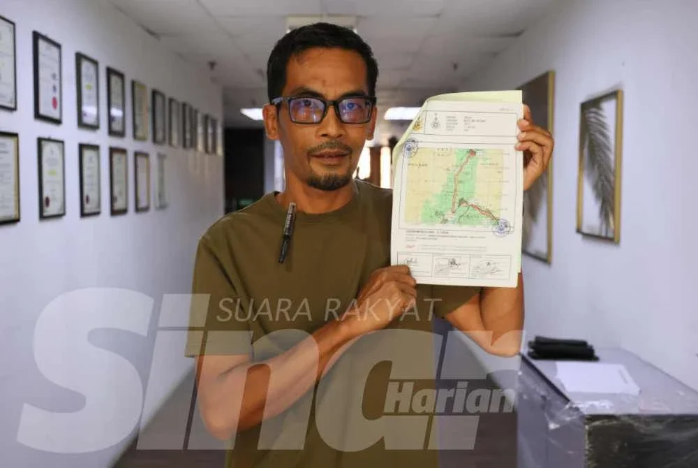 Ahmad Fauzan menunjukkan peta lokasi yang dibolehkan untuk mendulang emas di Kelantan.