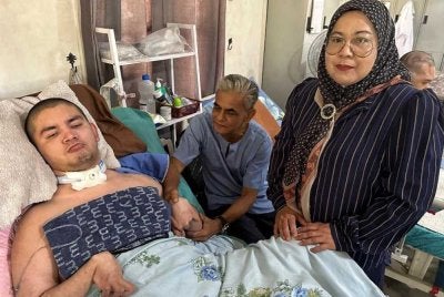 Yussery (tengah) dan Rozita (kanan) setia menjaga Danish yang terlantar sejak lima tahun lalu.