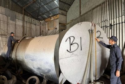 Anggota KPDN memeriksa skid tank ketika menyerbu sebuah kilang di Kulai pada Rabu. Foto: KPDN Johor