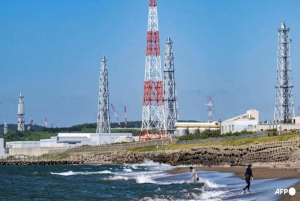 Gambar yang dirakam pada 5 Ogos 2024 menunjukkan Pantai Arahama berlatarbelakangkan loji janakuasa nuklear Kashiwazaki-Kariwa di wilayah Niigata, Jepun. (Foto fail: AFP/Yuichi Yamazaki)