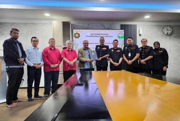 Karunanithy (lima dari kanan) menerima dokumen Laporan Penambahbaikan Tatakelola daripada Rosidi pada majlis yang diadakan di pejabat MAINPP pada Rabu.