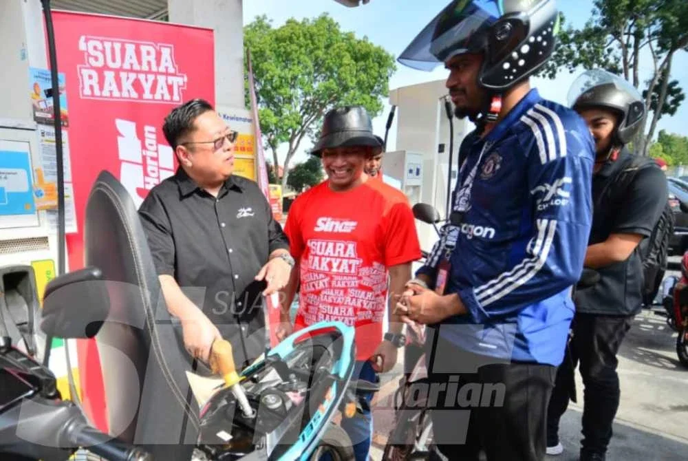 Hamdan (kiri) bersama Rosli (tengah) serta pelajar yang terlibat dalam program pengisian petrol percuma. Foto Sinar Harian - ASRIL ASWANDI SYUKUR