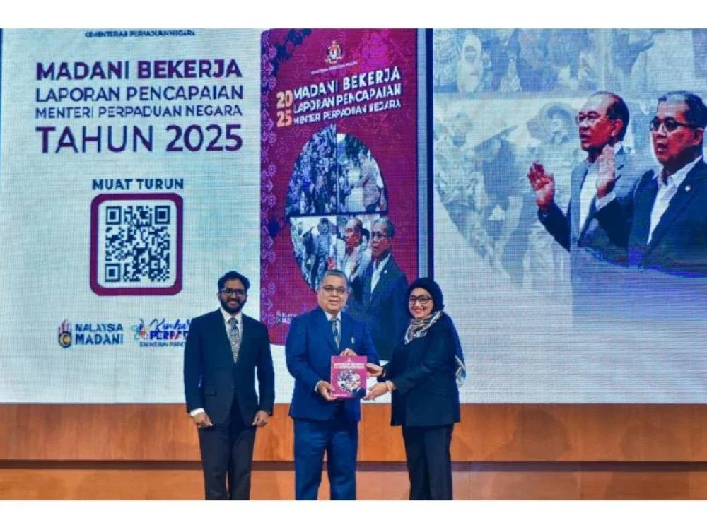 Aaron (tengah) menunjukkan buku Laporan Pencapaian Menteri Perpaduan Negara Tahun 2025. - Foto: Bernama