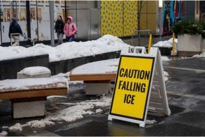 Papan tanda amaran dipasang susulan risiko ais jatuh selepas ribut salji melanda Manhattan, New York. - AFP