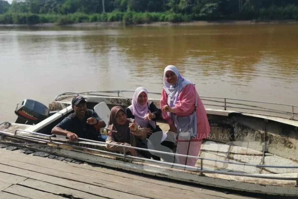 Siti Zamziah (kanan) bersama ibu dan adiknya selesai membuang undi dan bersedia untuk pulang menaiki bot ke Kampung Bilit Seberang, Sukau.