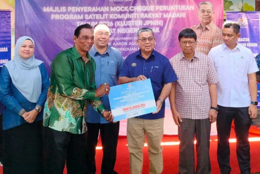 Aaron (tiga dari kanan) menyerahkan replika cek kepada penerima sempena Majlis Penyerahan Mock Cheque Peruntukan Program Satelit Komuniti Rakyat Madani Tahun 2026 Peringkat Ipoh di Pusat Nadi Kampung Dato’ Ahmad Said Tambahan 2 pada Sabtu.