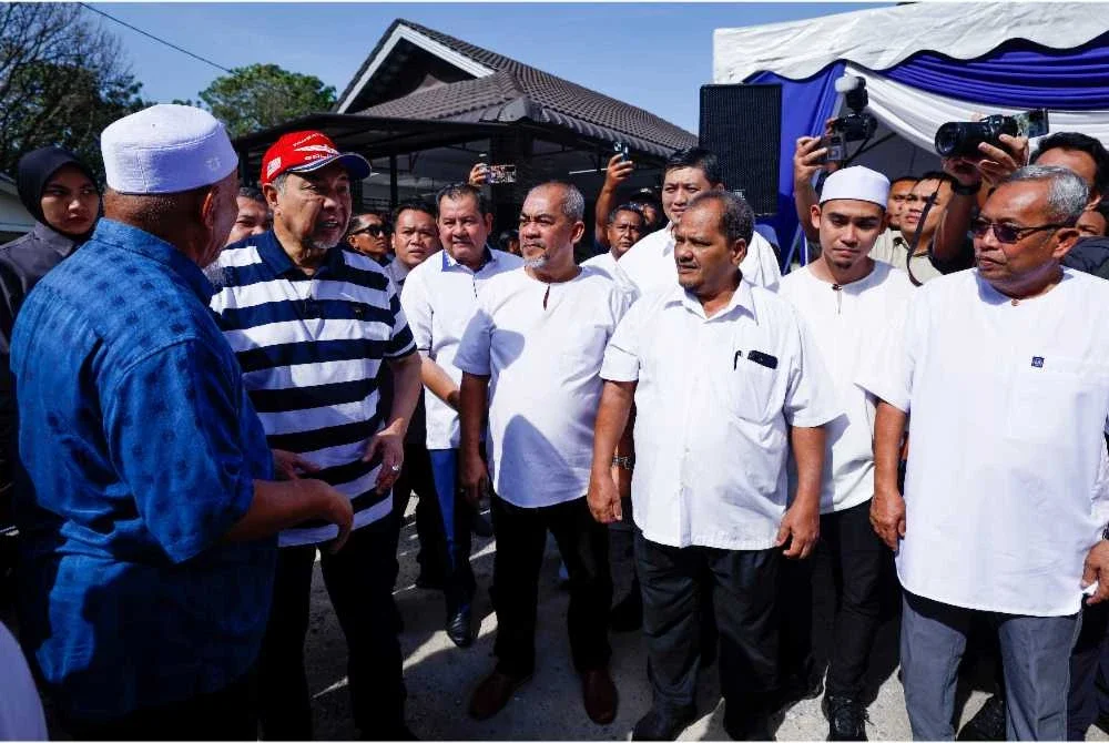 Ahmad Zahid (dua dari kiri) beramah mesra bersama tetamu yang hadir semasa mengadakan lawatan di Pondok Darul Muttaqin di Paya Rumput hari ini. - Foto: Bernama
