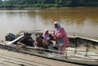 Siti Zamziah (kanan) bersama ibu dan adiknya selesai membuang undi dan bersedia untuk pulang menaiki bot ke Kampung Bilit Seberang, Sukau.