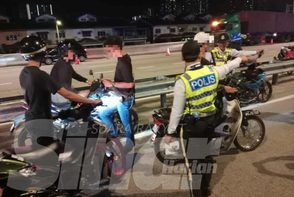 Anggota polis menjalankan pemeriksaan terhadap motosikal yang ditahan dalam operasi dijalankan pada Ahad.