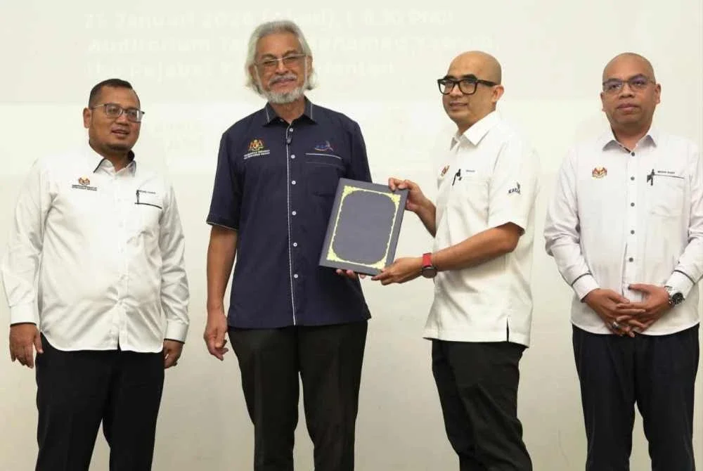 Khalid (dua dari kiri) menyampaikan anugerah pada Majlis Amanat Tahun Baharu KADA di Ibu Pejabat KADA, Kota Bharu pada Ahad.