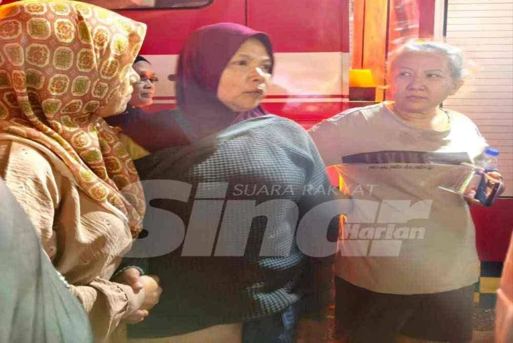 Norhaeda Azahari (tengah) hilang kata-kata dan ditenangkan oleh rakan-rakan selepas rumah nya terbakar sekali gus menyebabkan ibu angkat termasuk 70 ekor kucing serta lima anjing peliharaannya rentung dalam kejadian di Jalan Tok Guru, Kota Bharu pada Ahad.Foto: SINAR HARIAN/HAZELEN LIANA KAMARUDIN