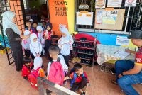 Siti Sarah Shammimie melihat murid-murid Tabika Kemas Taman Jujur memakai kasut untuk pulang.
