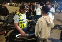 Mohd Zamzuri mendekati salah seorang penunggang motosikal yang ditahan dalam operasi yang dijalankan.