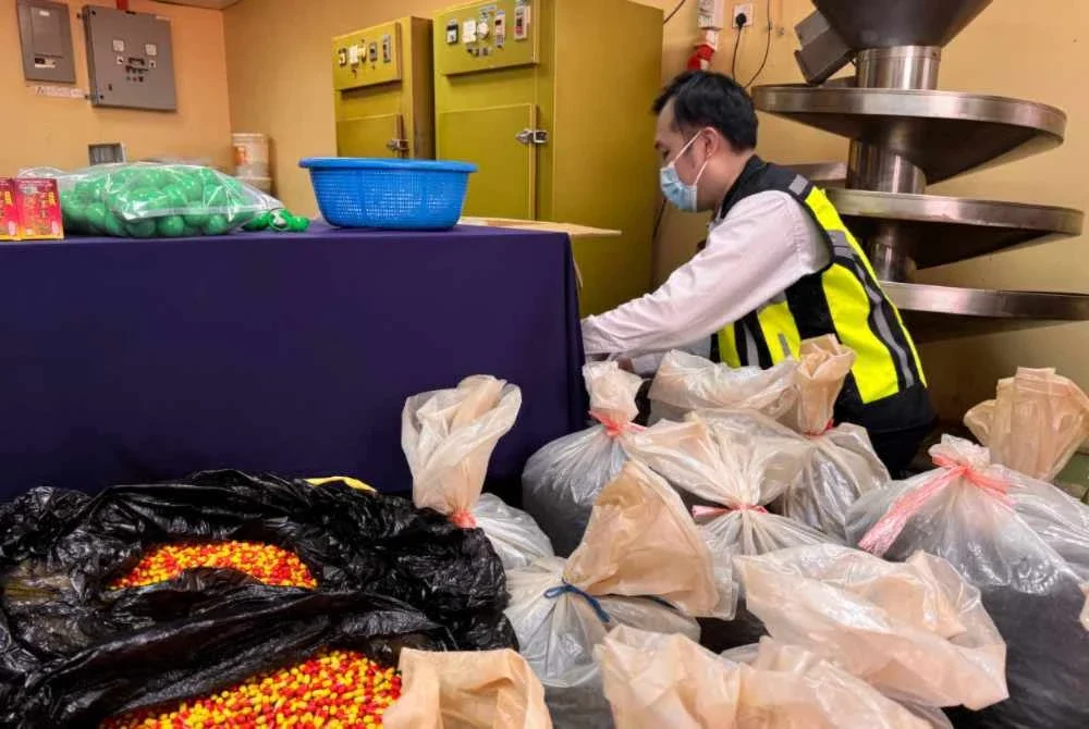 Pegawai KKM sedang memeriksa ubat-ubatan tidak berdaftar yang dirampas.