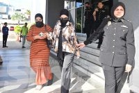 Salwani (dua, kanan) dihadapkan ke Mahkamah Sesyen Kuala Terengganu pada Isnin atas pertuduhan melibatkan kes pengubahan wang haram.