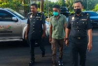 Jufri (tengah) diiringi anggota penguat kuasa SWCorp dibawa ke Mahkamah Sesyen Alor Setar pada Isnin.