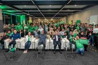 Adelene (duduk, dua dari kiri) dan Ramanan (duduk, tengah) bergambar bersama rakan penunggang dan pemandu Grab yang hadir pada majlis pelancaran Kampus Rakan Grab pada Isnin.