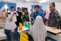 Mohamad (kanan) mengiringi Ramli menziarahi penghuni Pusat Jagaan Warga Emas Darul Hanan.