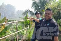 Suhaimi (kiri) menunjukkan lokasi kebakaran tanah gambut di Taman Bayu Damai, Pengerang sehingga penduduk terpaksa dipindahkan ke pusat transit sementara.