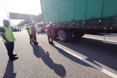 Anggota bomba menjalankan kerja mengeluarkan mangsa dalam kemalangan pada Isnin.