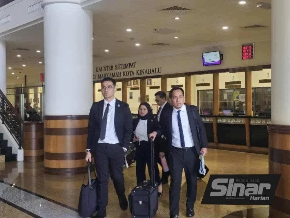 Shahlan (kanan) bersama rakan sepasukannya di pekarangan Kompleks Mahkamah Kota Kinabalu.