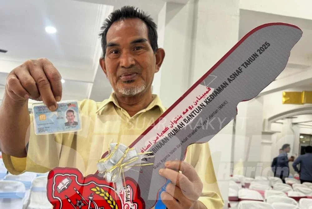 Sharuddin menunjukkan MyKad dan replika kunci rumah yang diperoleh daripada MAIK. 