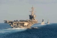 Kapal pengangkut pesawat USS Abraham Lincoln belayar melalui Selat Hormuz pada 2019, diiringi oleh kapal peronda pertahanan udara HMS Defender dan kapal peronda peluru berpandu USS Farragut. - AFP