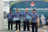Tengku Mohamad Rizam (dua dari kanan) menyampaikan replika bantuan persekolahan kepada wakil masjid. 
Foto: SINAR HARIAN/ADILA SHARINNI WAHID