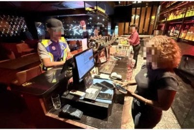 Anggota polis membuat pemeriksaan di salah satu premis yang diserbu.