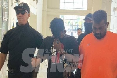 Sathiyaseelan yang memakai baju T berwarna hitam (tengah) dan Balaraj berbaju T warna jingga (kanan) dibawa ke Mahkamah Sesyen Klang pada Selasa.