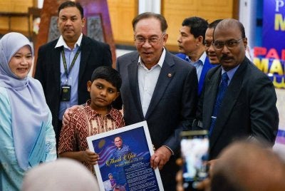 Perdana Menteri, Datuk Seri Anwar Ibrahim menyantuni 'peminat ciliknya' ketika hadir pada Mesyuarat Pertama, Penggal Kelima Parlimen ke-15 Dewan Rakyat di Bangunan Parlimen hari ini. Foto Bernama 