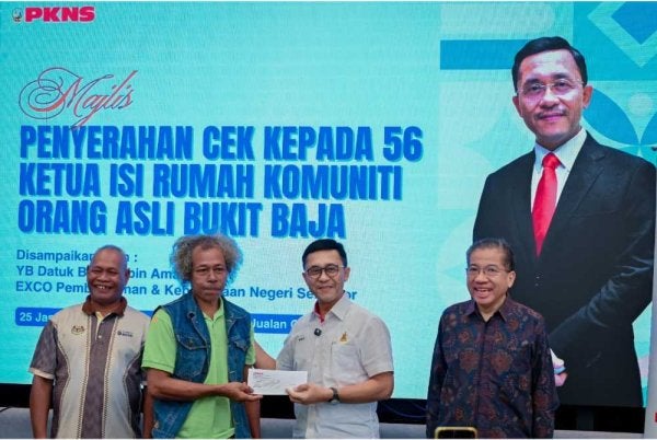 Borhan (dua dari kanan) diiringi Md Kamarzan (kanan) menyerahkan cek sumbangan kepada salah seorang penerima di Galeri PKNS Cyber Valley pada Selasa.