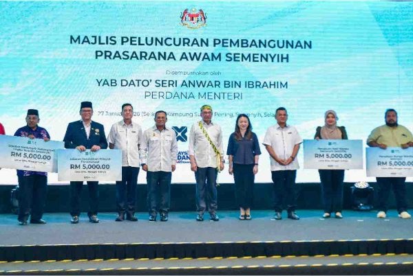 Anwar (lima dari kiri) bergambar bersama penerima sumbangan daripada 12 institusi di sekitar Semenyih pada Majlis Pelancaran Pembangunan Prasarana Awam Semenyih di Jalan Sungai Pening, pada Selasa. Turut hadir Menteri di Jabatan Perdana Menteri (Wilayah Persekutuan), Hannah Yeoh dan Menteri Besar Selangor, Datuk Seri Amirudin Shari. Foto Bernama