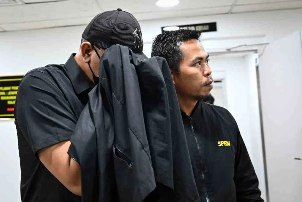 Koperal Azizol Affendi Rusli (kiri) didenda RM4,000 oleh Mahkamah Sesyen Kuala Terengganu hari ini kerana menerima wang rasuah untuk tidak menahan suspek narkotik. Foto Bernama